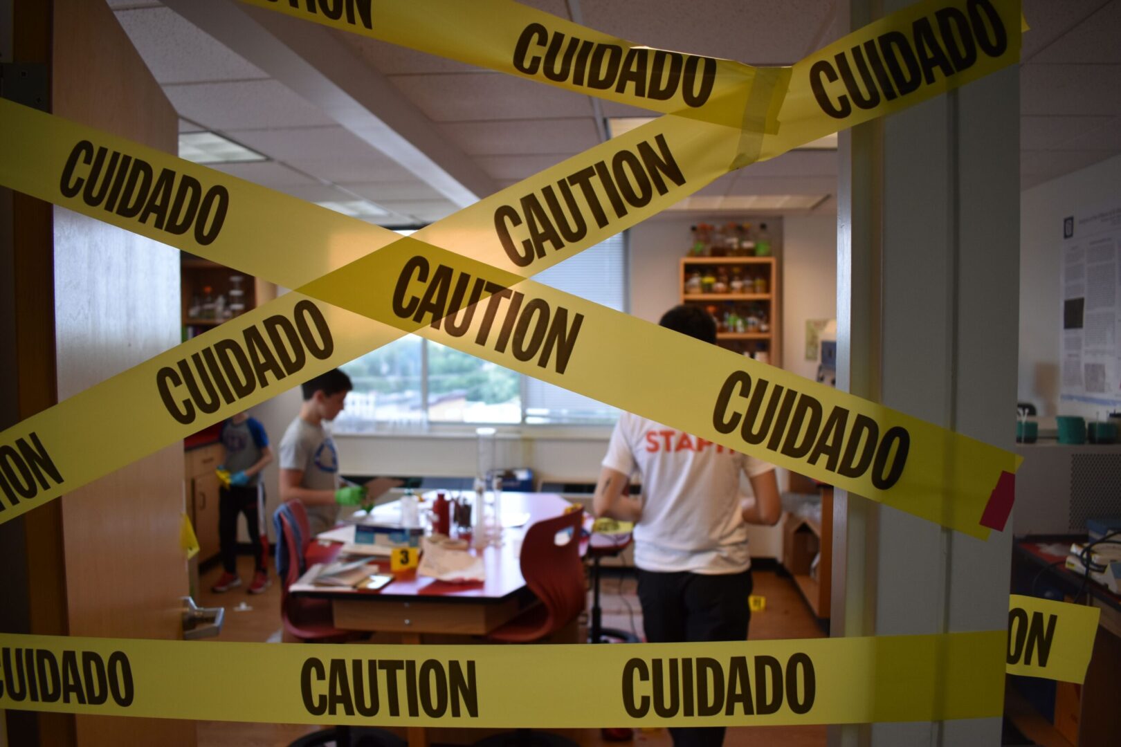 A group of people standing around a table with caution tape.
