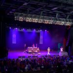 A Crowd Of People Watching An Audience On Stage.